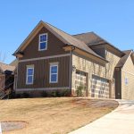 Cozy family home for sale in suburb with spacious garage and landscaped lawn.